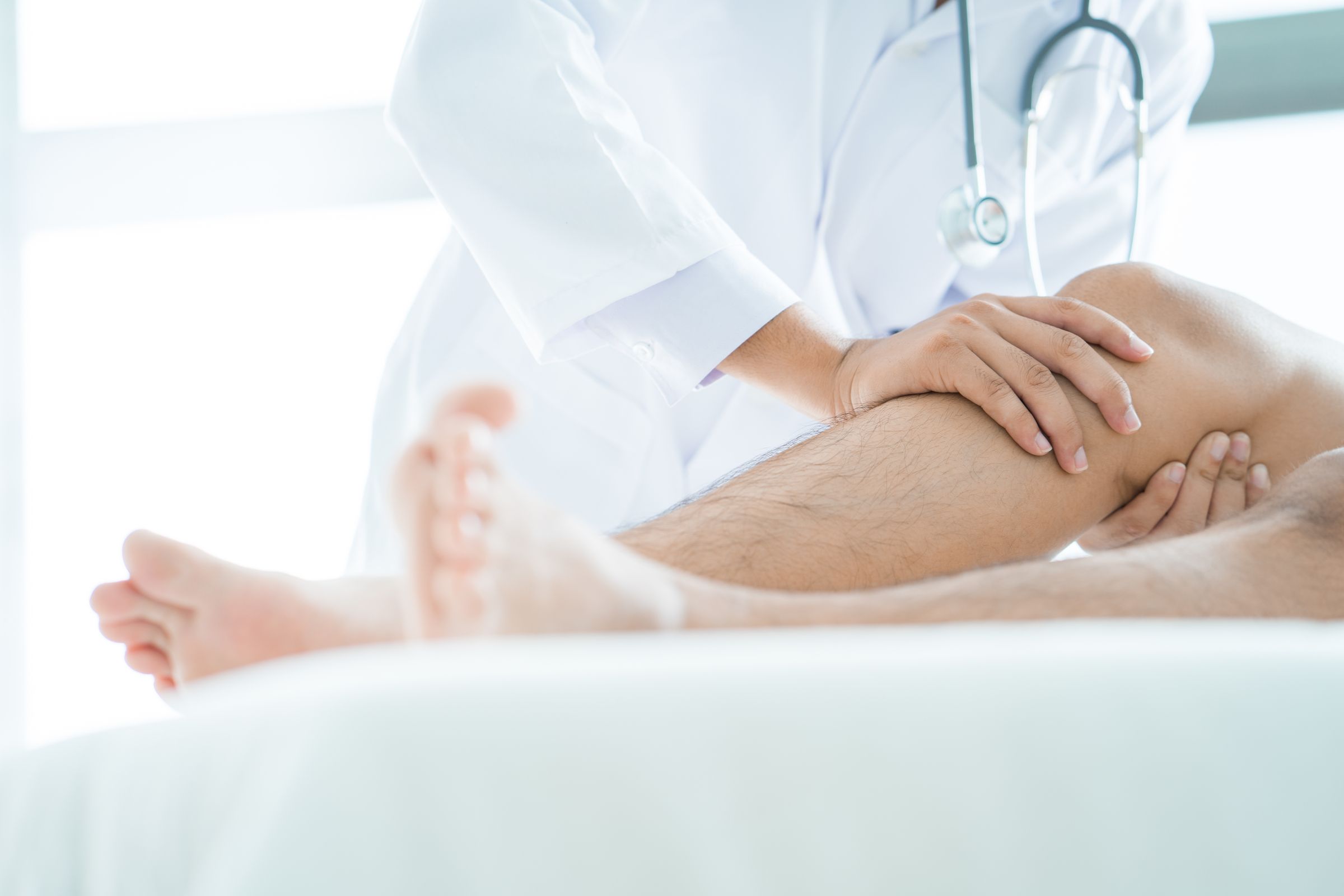 Arzt prüft die Funktionalität des Knies